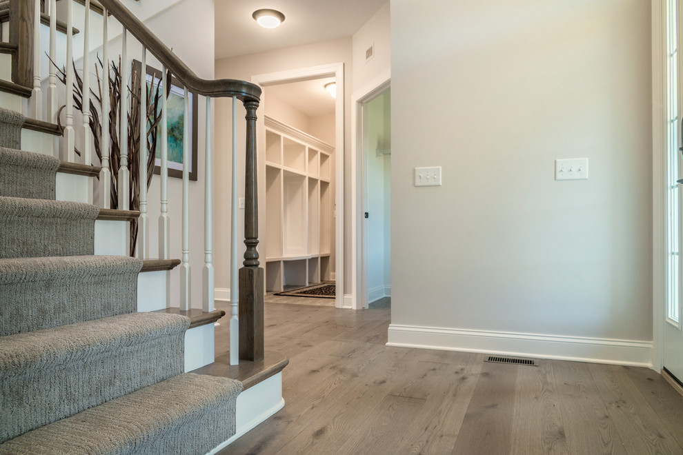 Design ideas for a mid-sized modern foyer in New York with grey walls, light hardwood floors, a single front door, a white front door and grey floor.