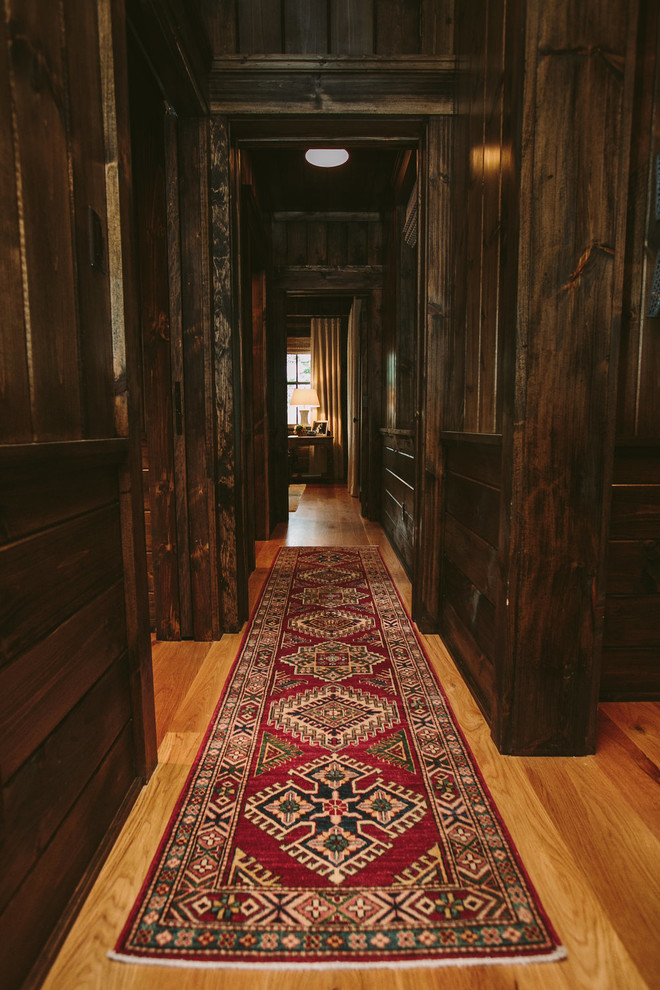 This is an example of a mid-sized country hallway in Baltimore with brown walls and light hardwood floors.