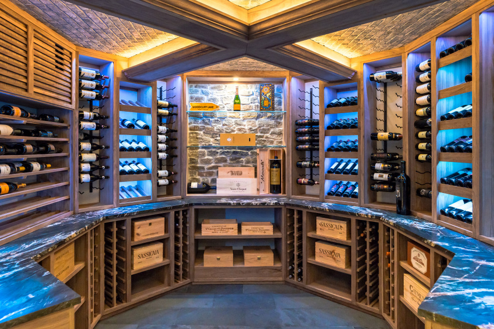 This is an example of a large country wine cellar in New York with slate floors, display racks and black floor.