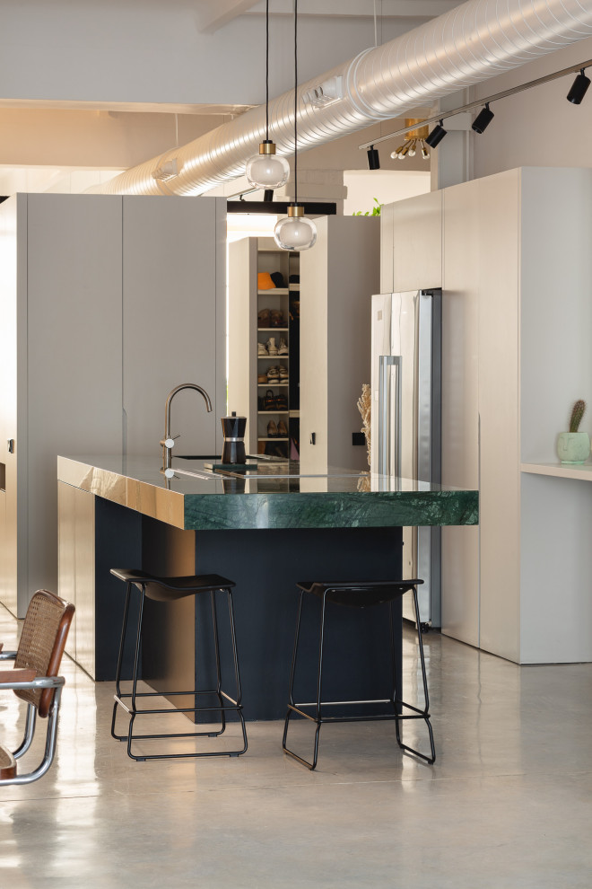 Photo of a medium sized contemporary kitchen/diner in Alicante-Costa Blanca with marble worktops, marble splashback, concrete flooring, an island and green worktops.
