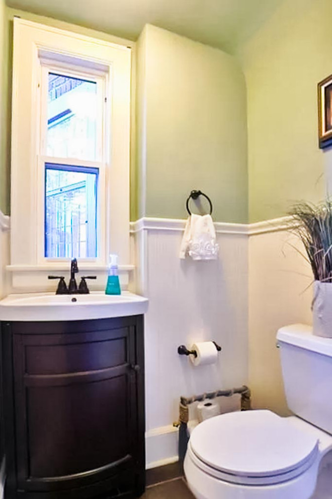 This is an example of a traditional powder room in Cleveland with shaker cabinets, dark wood cabinets, ceramic floors, white benchtops, a freestanding vanity and decorative wall panelling.