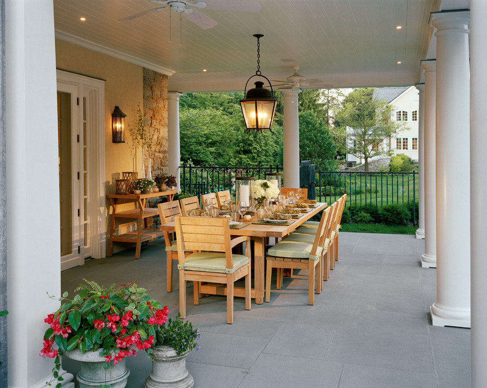 Mid-sized elegant backyard concrete paver patio photo in New York with a roof extension