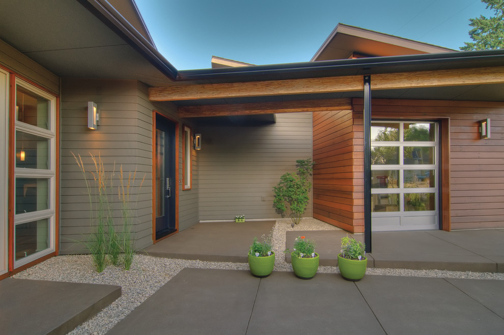 Example of a small transitional courtyard concrete drought-tolerant patio design with a roof extension