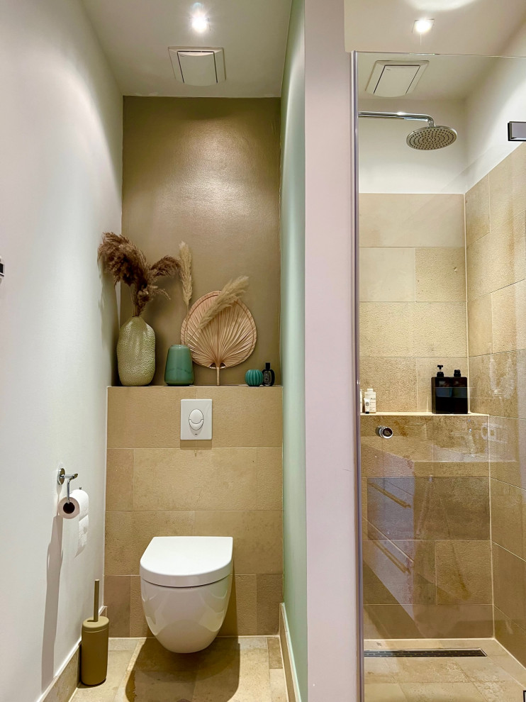 На фото: туалет среднего размера в современном стиле с инсталляцией, коричневой плиткой, каменной плиткой, зелеными стенами, полом из известняка, коричневым полом, потолком с обоями и обоями на стенах
