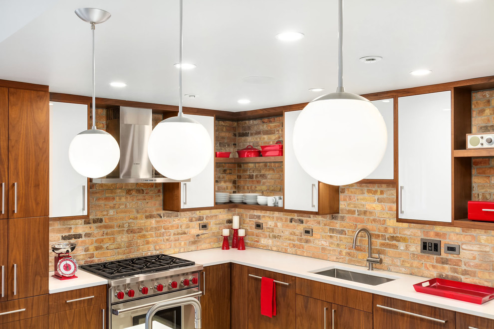 This is an example of a mid-sized midcentury l-shaped eat-in kitchen in Chicago with an undermount sink, flat-panel cabinets, white cabinets, brown splashback, brick splashback, stainless steel appliances, terrazzo floors, with island, beige floor and quartz benchtops.