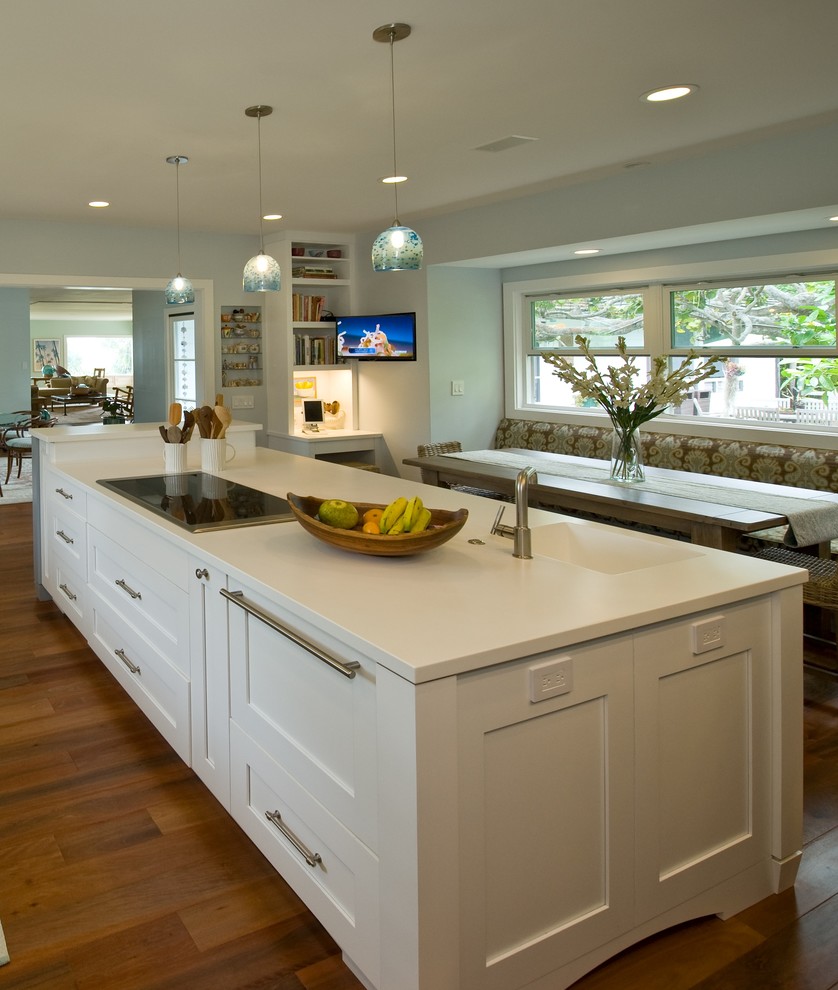 This is an example of a tropical kitchen pantry in Hawaii with an integrated sink, shaker cabinets, blue cabinets, solid surface benchtops, panelled appliances and with island.