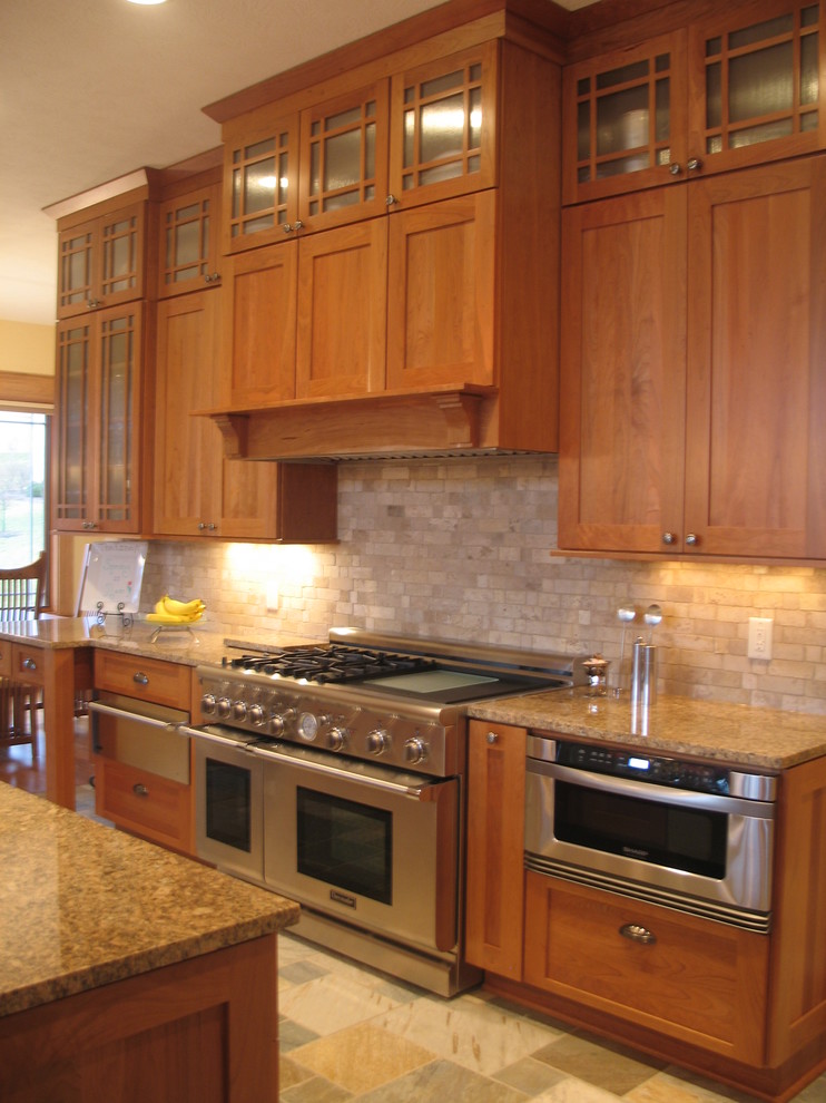 Mid-sized arts and crafts galley eat-in kitchen in Indianapolis with an undermount sink, recessed-panel cabinets, light wood cabinets, granite benchtops, black splashback, stone tile splashback, stainless steel appliances, slate floors and with island.