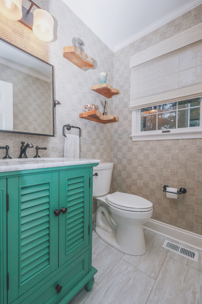 Foto på ett litet eklektiskt vit toalett, med luckor med lamellpanel, gröna skåp, en toalettstol med separat cisternkåpa, beige väggar, laminatgolv, ett undermonterad handfat, marmorbänkskiva och beiget golv