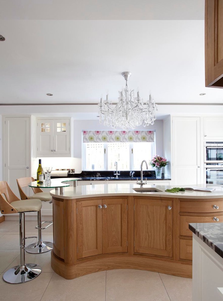 Design ideas for a mid-sized traditional kitchen in Other with an undermount sink, recessed-panel cabinets, medium wood cabinets, quartzite benchtops, black splashback, stone slab splashback, stainless steel appliances, ceramic floors and with island.