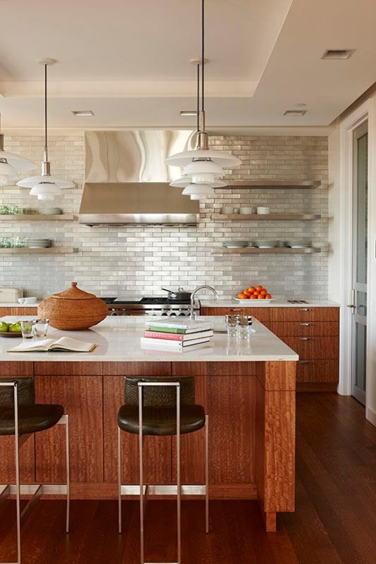 This is an example of a contemporary open plan kitchen in Detroit with stainless steel appliances, dark hardwood floors and multiple islands.