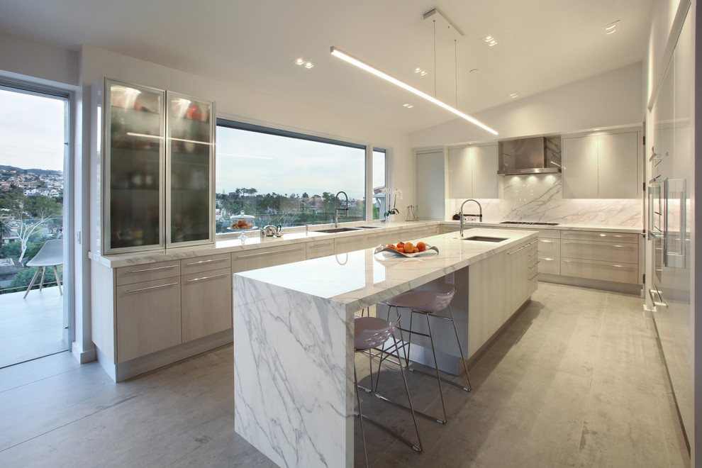 Design ideas for a large contemporary u-shaped open plan kitchen in Orange County with an undermount sink, flat-panel cabinets, white cabinets, white splashback, panelled appliances, with island, grey floor, white benchtop and stone slab splashback.