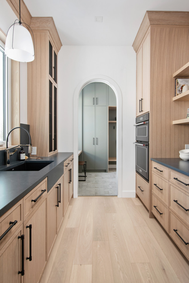 Kitchen - mid-sized transitional galley light wood floor kitchen idea with shaker cabinets, quartz countertops, quartz backsplash, stainless steel appliances and an island