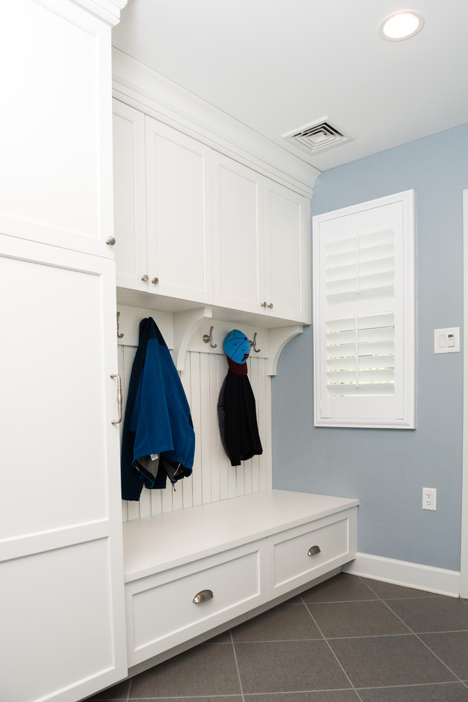 Example of a mid-sized transitional u-shaped ceramic tile and gray floor entryway design in Philadelphia with shaker cabinets, white cabinets, solid surface countertops, gray walls and a side-by-side washer/dryer