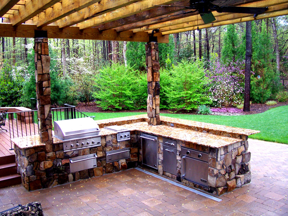 Patio kitchen - mid-sized rustic backyard concrete paver patio kitchen idea with a pergola