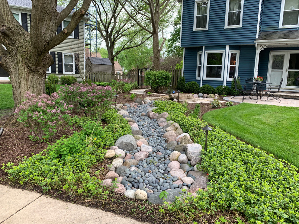 Inspiration for a mid-sized traditional front yard partial sun garden for summer in Chicago with with rock feature and river rock.