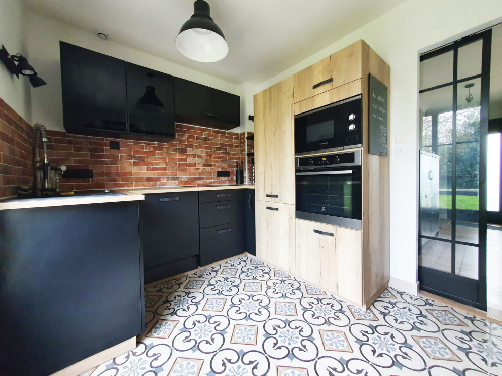 Diseño de cocina urbana de tamaño medio cerrada con puertas de armario negras, encimera de laminado, salpicadero de azulejos en listel y suelo de azulejos de cemento