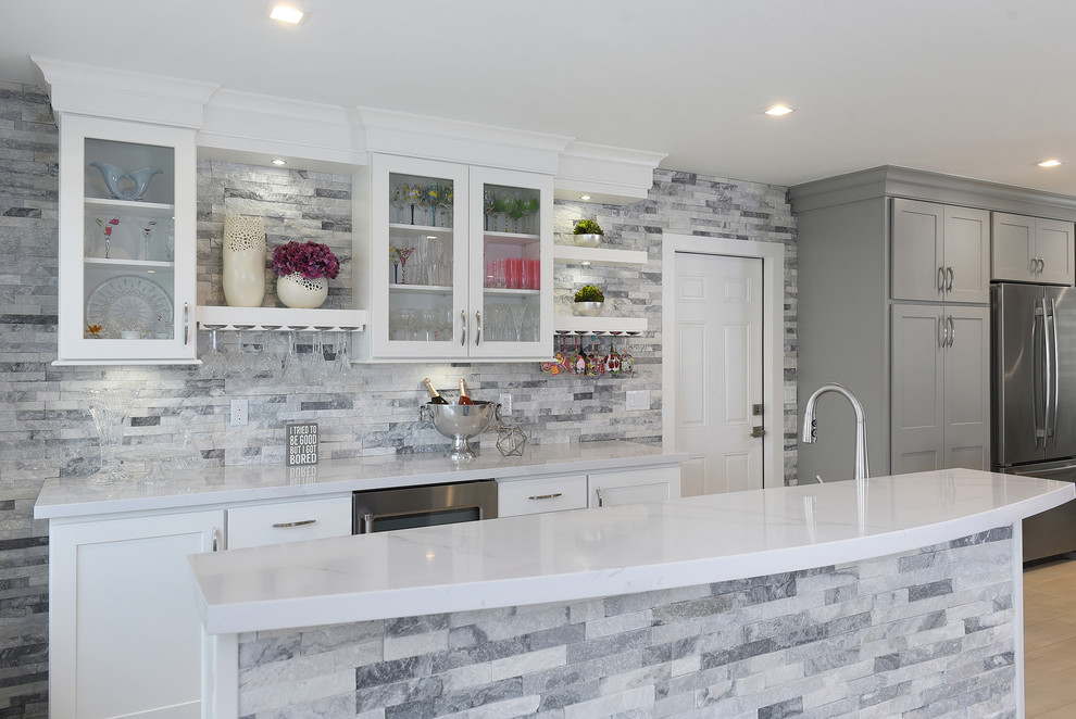 Open concept kitchen - large transitional l-shaped porcelain tile and gray floor open concept kitchen idea in Miami with a farmhouse sink, shaker cabinets, gray cabinets, quartz countertops, gray backsplash, marble backsplash, stainless steel appliances and two islands