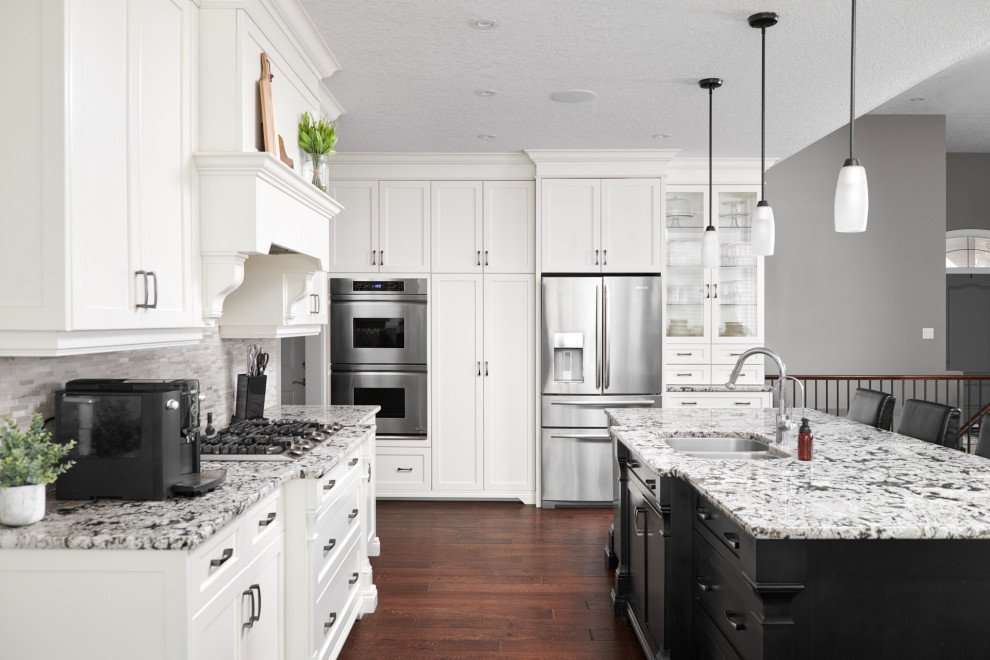 Transitional dark wood floor and brown floor open concept kitchen photo in Toronto with an undermount sink, shaker cabinets, white cabinets, granite countertops, gray backsplash, stone slab backsplash, stainless steel appliances, an island and gray countertops