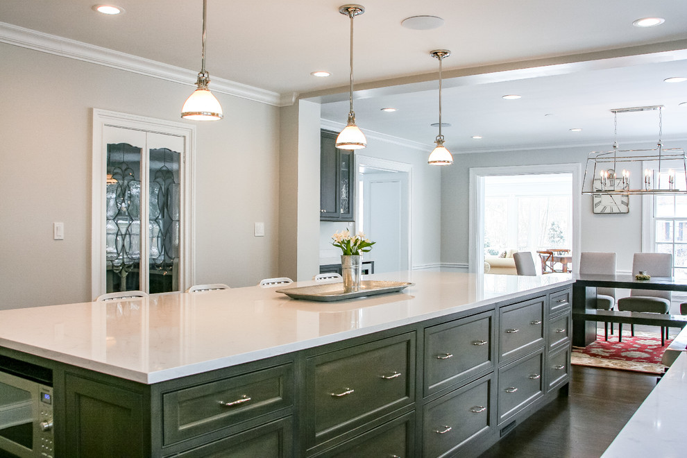 Inspiration for a large traditional galley eat-in kitchen in Chicago with a farmhouse sink, shaker cabinets, white cabinets, quartz benchtops, white splashback, porcelain splashback, stainless steel appliances, with island and white benchtop.