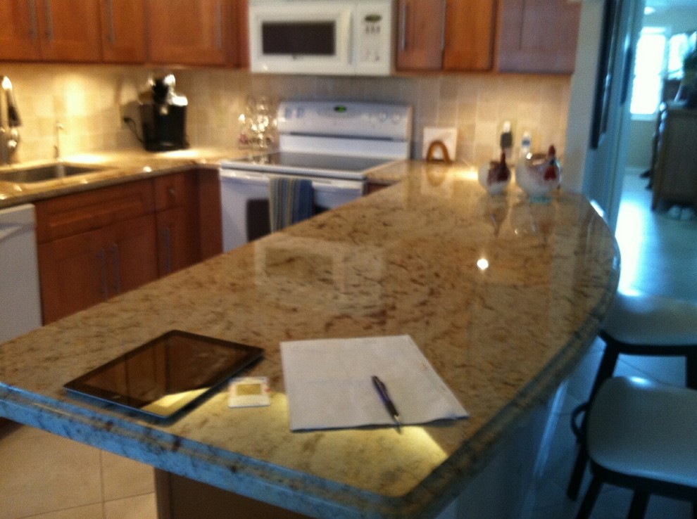 Example of a mid-sized transitional u-shaped ceramic tile kitchen pantry design in Miami with an undermount sink, shaker cabinets, medium tone wood cabinets, granite countertops, beige backsplash, ceramic backsplash, white appliances and a peninsula