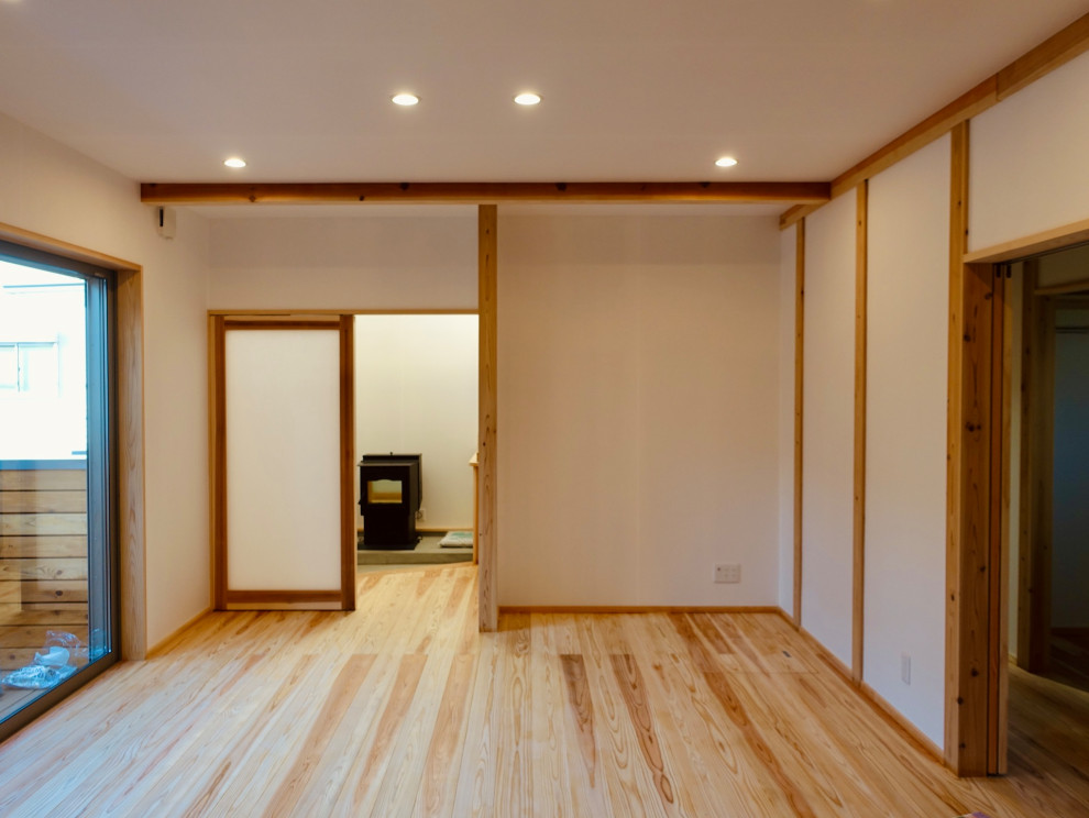 Réalisation d'une salle de séjour avec un sol en bois brun, un poêle à bois, un sol beige, un plafond en papier peint et du papier peint.
