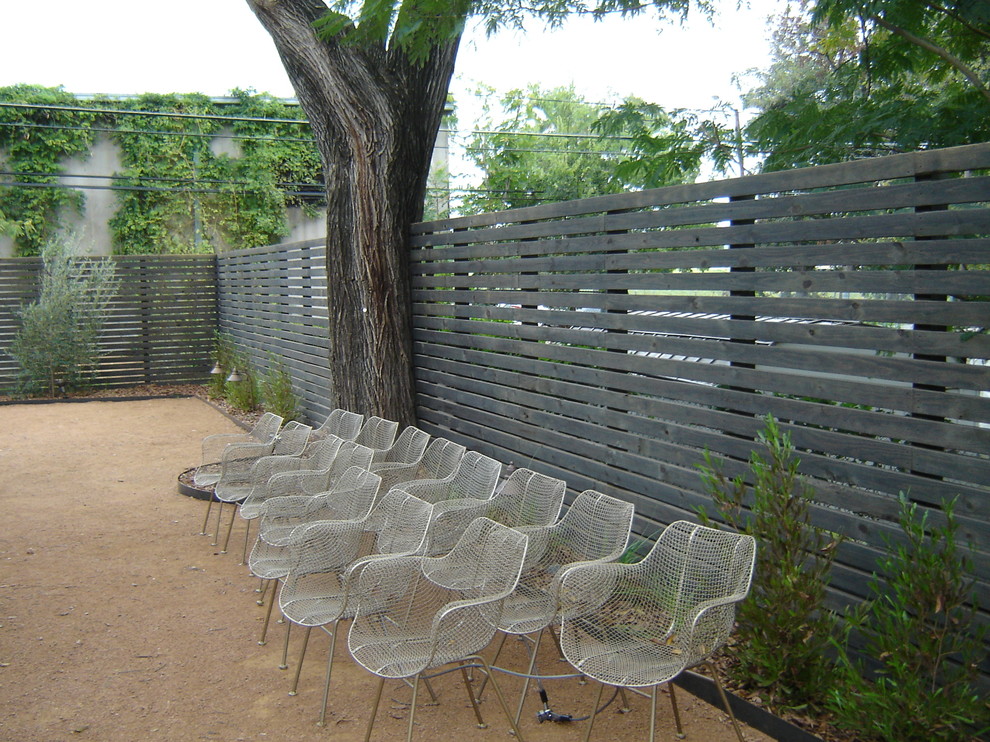 This is an example of a mid-sized traditional backyard full sun garden for spring in Austin with a retaining wall.