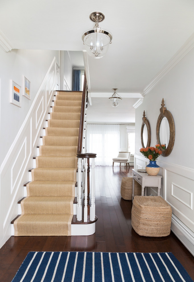 Photo of an expansive beach style wood straight staircase in New York with painted wood risers.
