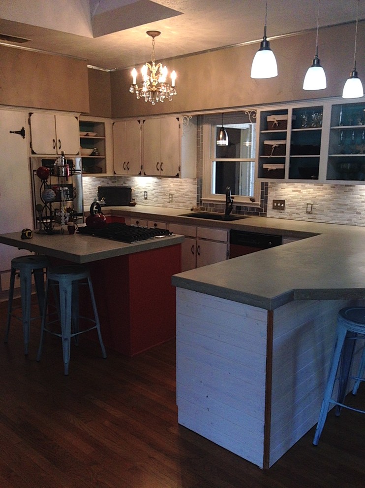 Photo of a mid-sized eclectic u-shaped eat-in kitchen in Austin with an undermount sink, flat-panel cabinets, white cabinets, concrete benchtops, multi-coloured splashback, matchstick tile splashback, stainless steel appliances, dark hardwood floors, a peninsula and brown floor.