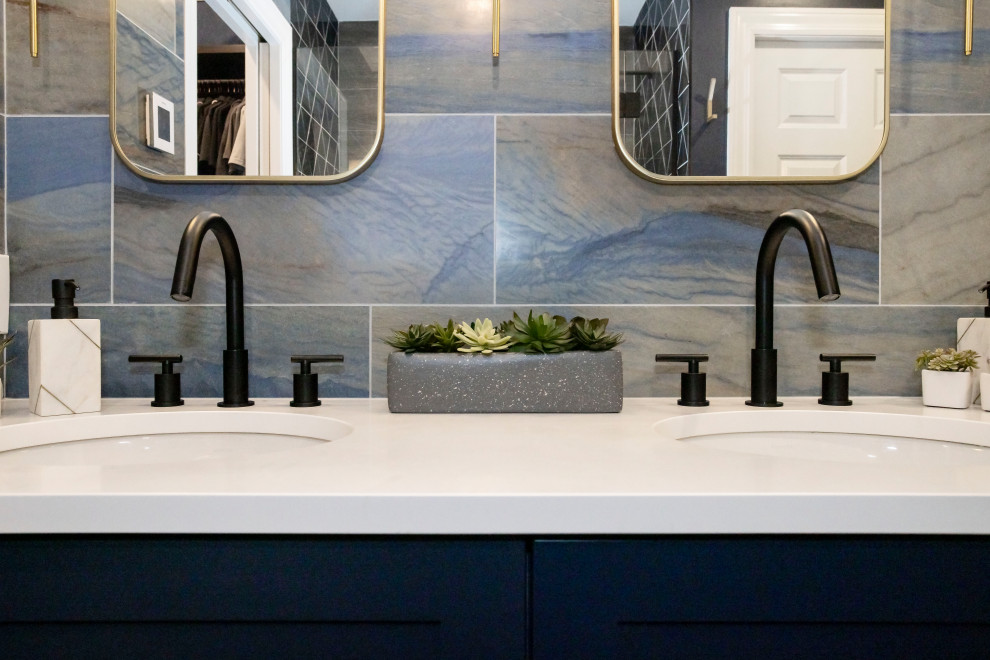 This is an example of a mid-sized modern master bathroom in Chicago with shaker cabinets, blue cabinets, an alcove shower, a two-piece toilet, multi-coloured tile, porcelain tile, multi-coloured walls, wood-look tile, an undermount sink, grey floor, white benchtops, a niche, a double vanity and a built-in vanity.