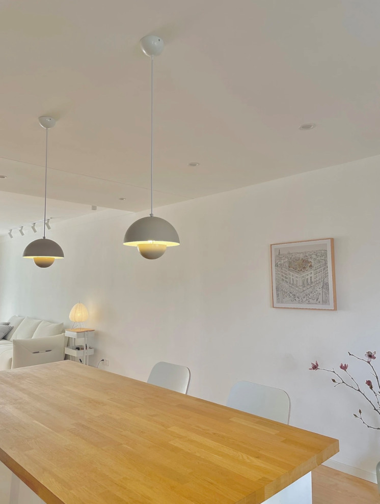 Idee per una piccola sala da pranzo aperta verso la cucina contemporanea con pareti bianche, parquet chiaro e pavimento giallo