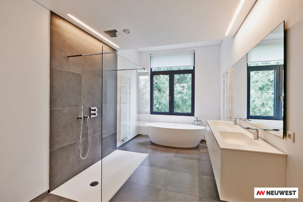 Modern inredning av ett beige beige badrum med dusch, med ett fristående badkar, en kantlös dusch och med dusch som är öppen