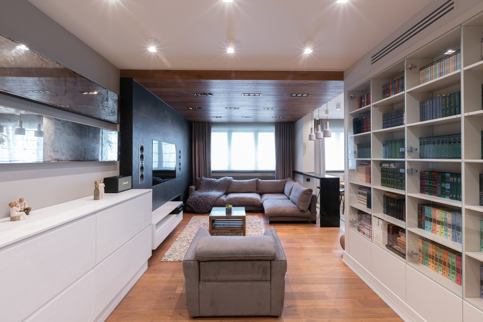 Идея дизайна: открытая гостиная комната в современном стиле с паркетным полом среднего тона, телевизором на стене и коричневым полом