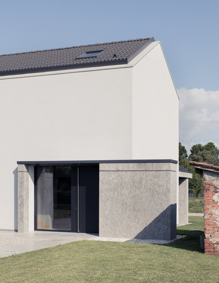 Esempio della facciata di una casa contemporanea a due piani di medie dimensioni con rivestimento in cemento