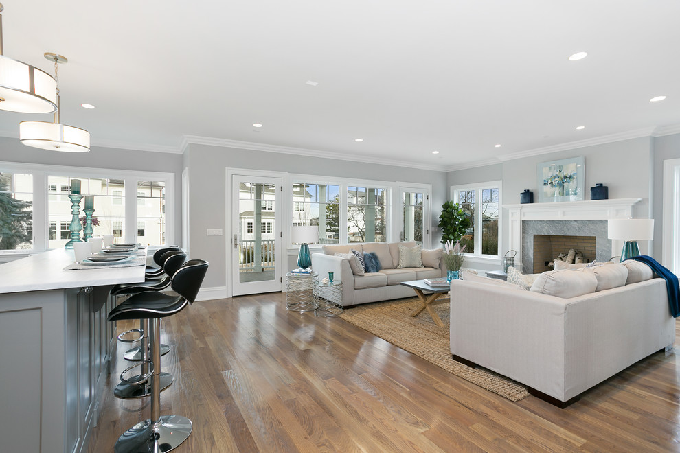 Large beach style open concept family room in New York with grey walls, dark hardwood floors and no tv.