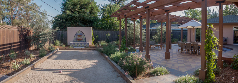 Design ideas for a mid-sized mediterranean backyard partial sun garden in Sacramento with a water feature.