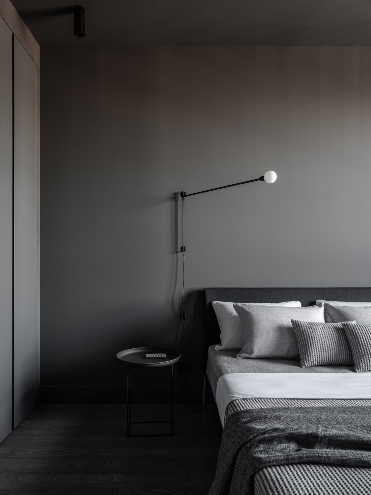 На фото: хозяйская, серо-белая спальня среднего размера: освещение в стиле лофт с серыми стенами, паркетным полом среднего тона и серым полом