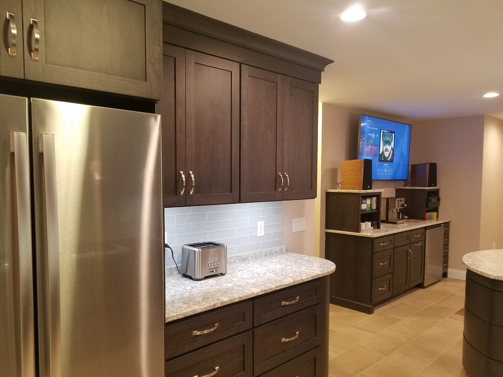 Example of a large transitional l-shaped porcelain tile and beige floor eat-in kitchen design with a farmhouse sink, shaker cabinets, black cabinets, quartz countertops, blue backsplash, ceramic backsplash, stainless steel appliances, a peninsula and white countertops