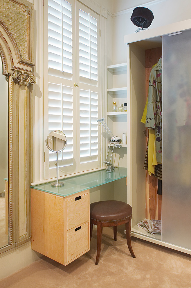 Design ideas for an eclectic women's dressing room in New Orleans with glass-front cabinets.