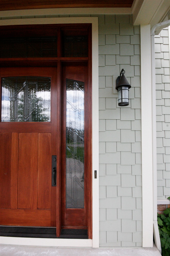 This is an example of an expansive arts and crafts front door in Detroit with green walls, a single front door and a medium wood front door.