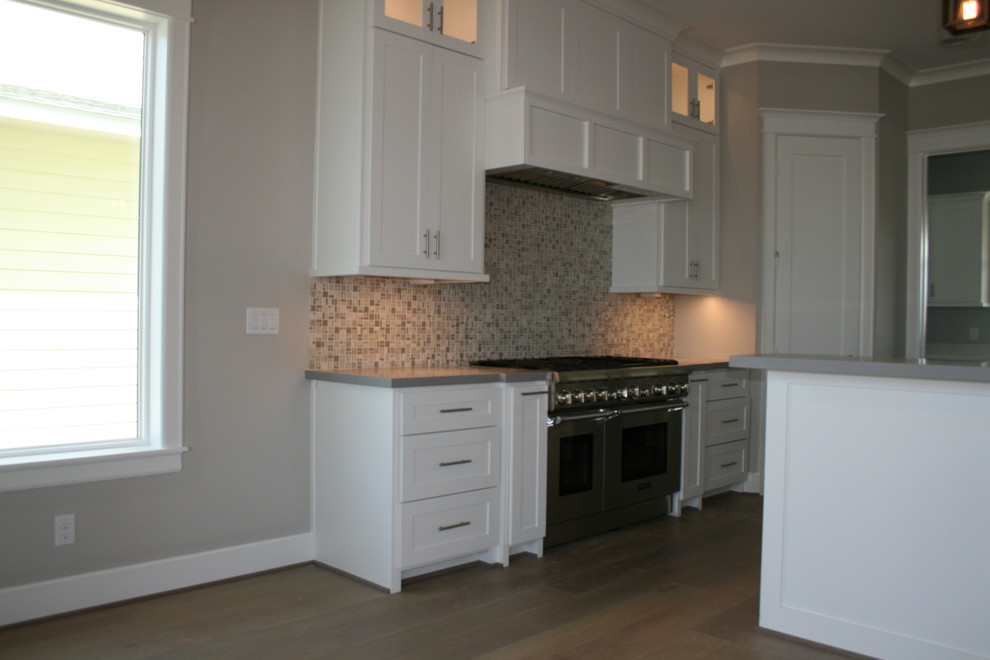 Inspiration for a large transitional l-shaped light wood floor and brown floor open concept kitchen remodel in Houston with an undermount sink, shaker cabinets, white cabinets, quartzite countertops, multicolored backsplash, mosaic tile backsplash, stainless steel appliances and two islands