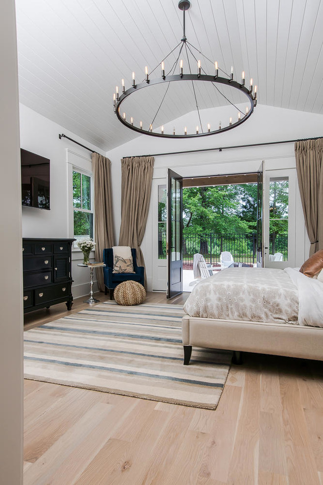 Large country master bedroom in Raleigh with white walls and beige floor.