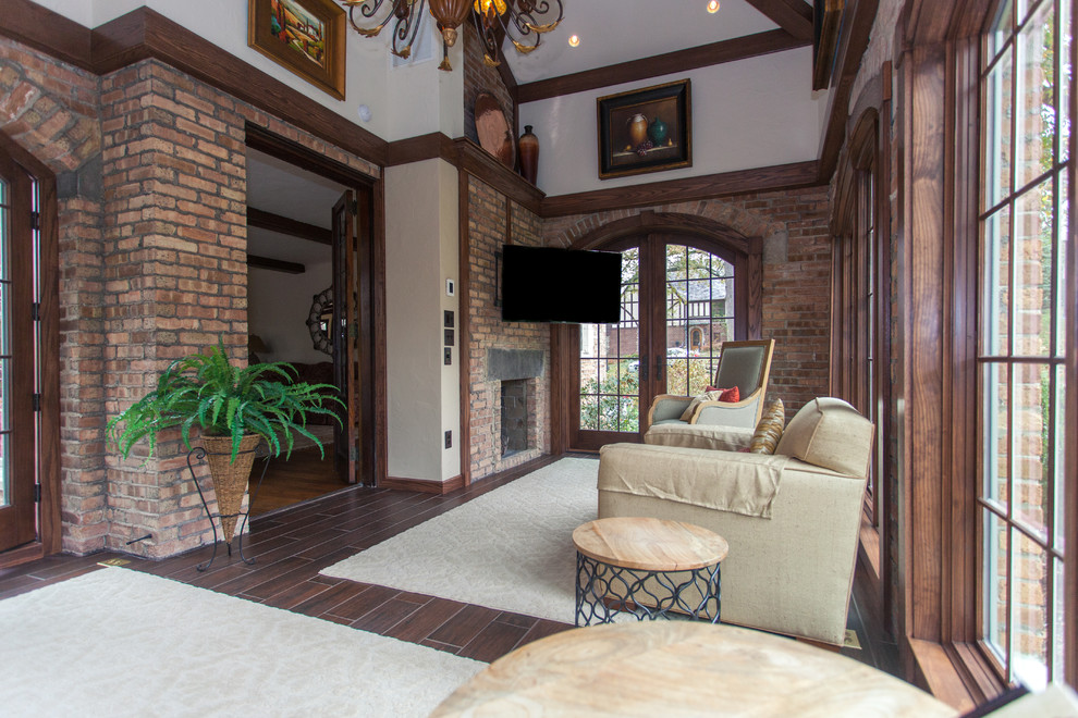 Inspiration for a mid-sized transitional sunroom in Cincinnati with dark hardwood floors, a two-sided fireplace, a brick fireplace surround and a standard ceiling.