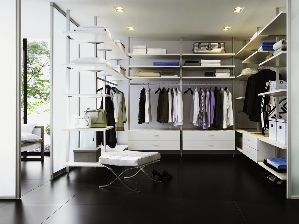 Large contemporary gender-neutral walk-in wardrobe in Moscow with open cabinets, laminate floors and black floor.