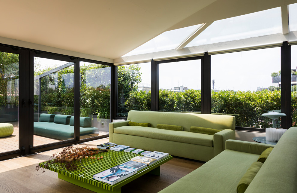 Immagine di una grande veranda contemporanea con pavimento in legno massello medio e lucernario