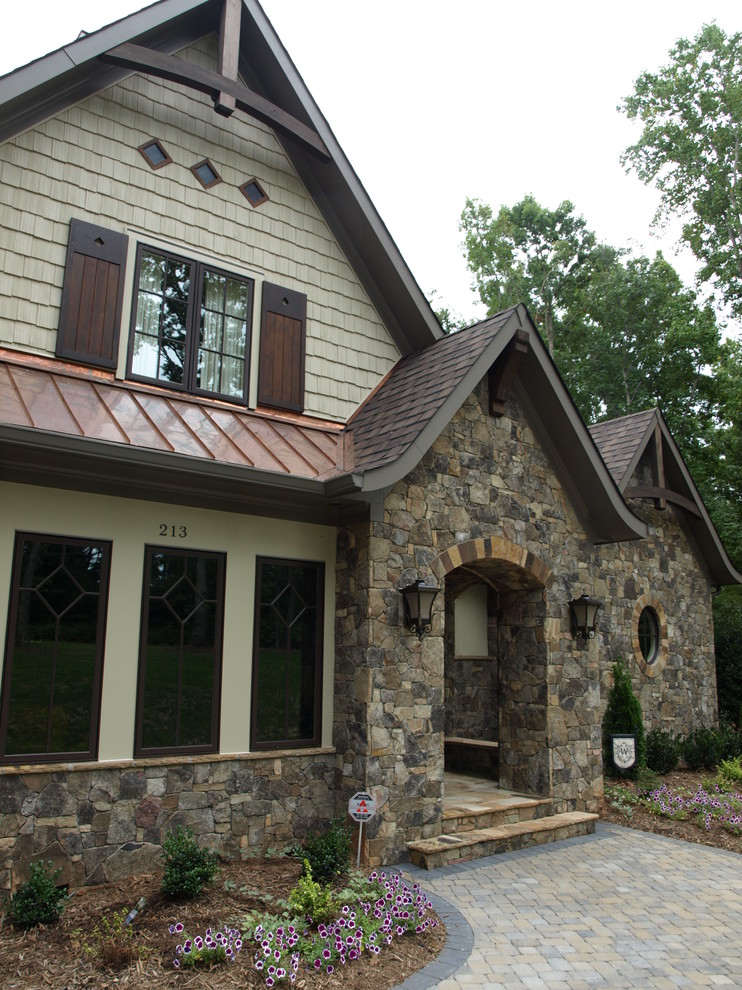 Photo of a large arts and crafts two-storey brown exterior in Charlotte with stone veneer.