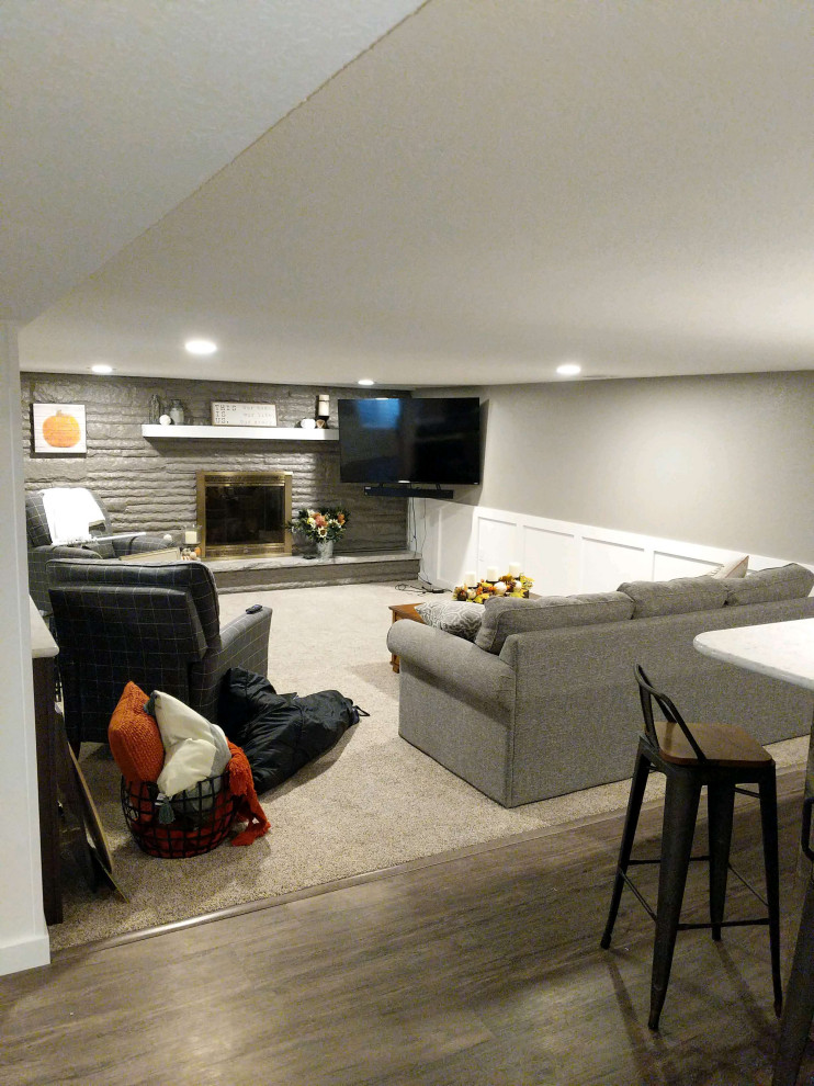 Design ideas for a large arts and crafts fully buried basement in Detroit with grey walls, vinyl floors, a standard fireplace, a brick fireplace surround and grey floor.