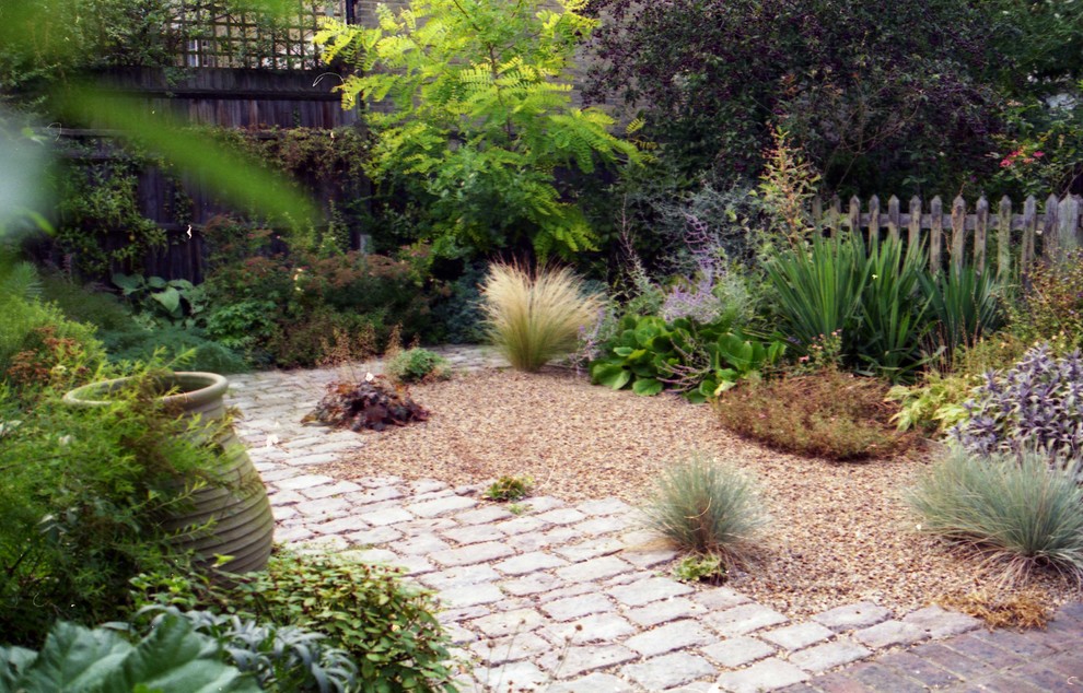This is an example of a small mediterranean backyard full sun xeriscape in London with natural stone pavers.
