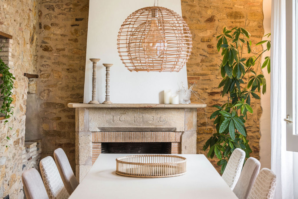 Diseño de comedor de estilo de casa de campo de tamaño medio con suelo de baldosas de terracota, todas las chimeneas, marco de chimenea de piedra, vigas vistas y todos los tratamientos de pared