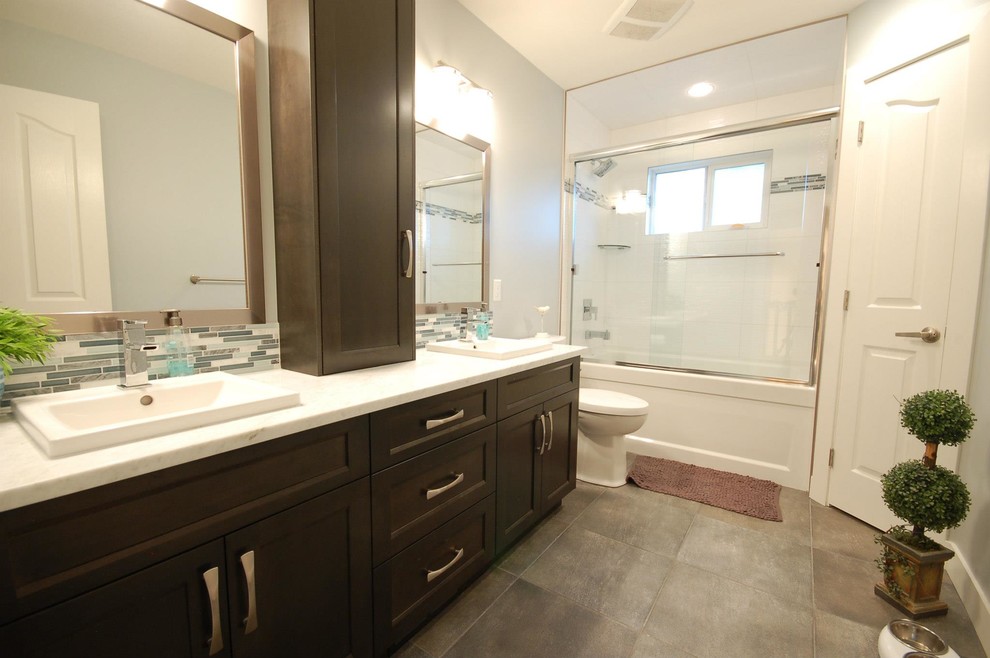 Design ideas for a large contemporary master bathroom in Vancouver with shaker cabinets, dark wood cabinets, an alcove tub, a shower/bathtub combo, a two-piece toilet, blue tile, gray tile, white tile, matchstick tile, blue walls, ceramic floors, a drop-in sink and engineered quartz benchtops.
