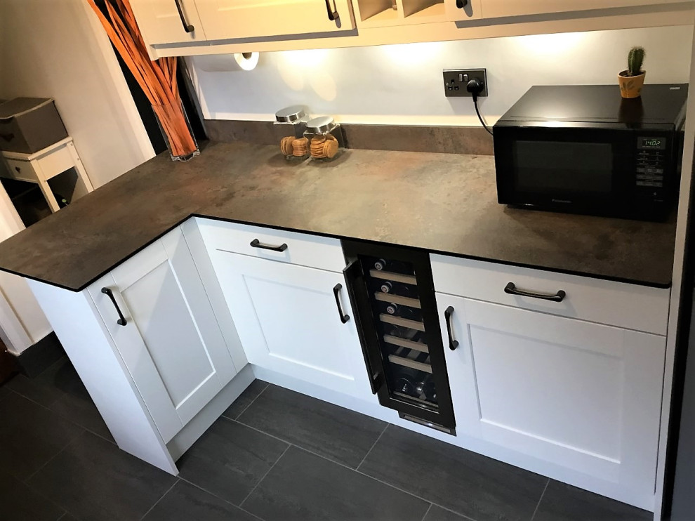 Inspiration for a mid-sized galley separate kitchen in Other with shaker cabinets, orange splashback, glass sheet splashback, porcelain floors, a peninsula and grey floor.